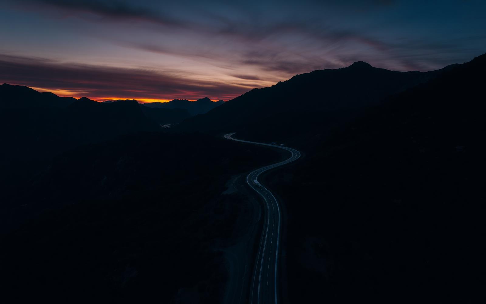 Highway at dusk winding through mountains